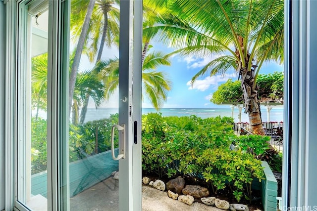 doorway to outside featuring a wealth of natural light, a water view, and concrete floors