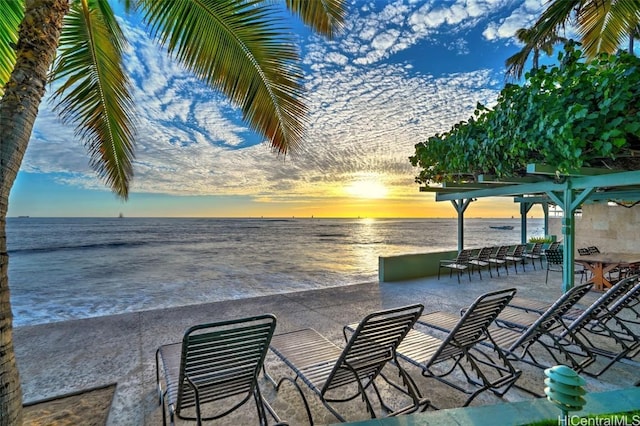 patio terrace at dusk featuring a water view