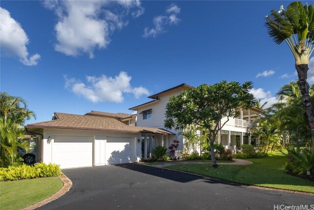 view of front facade featuring a garage, a balcony, and a front yard