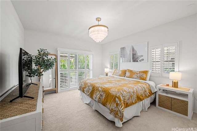 bedroom featuring access to exterior and light carpet