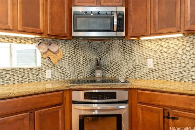 kitchen featuring light stone countertops, appliances with stainless steel finishes, and decorative backsplash