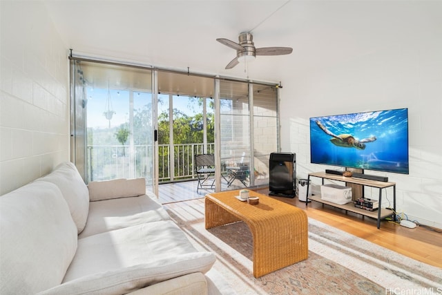 living room with hardwood / wood-style flooring, a wall of windows, and ceiling fan