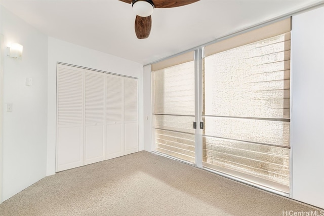 unfurnished bedroom with carpet floors, ceiling fan, and a closet