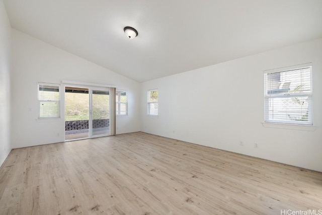 spare room with vaulted ceiling and light hardwood / wood-style flooring