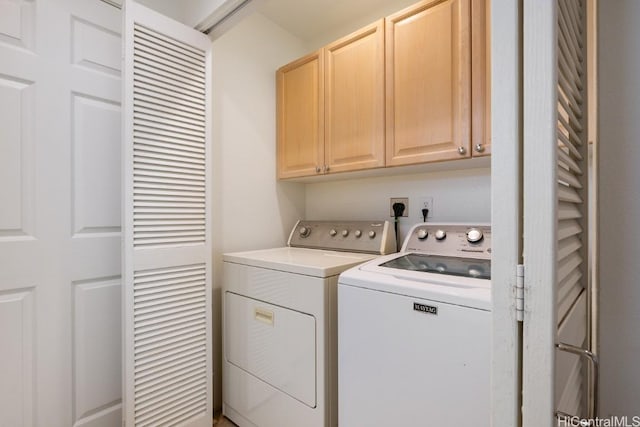 laundry room featuring washer and clothes dryer and cabinets