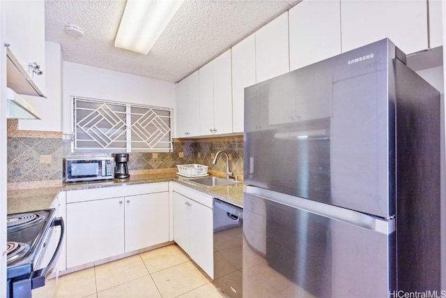 kitchen with appliances with stainless steel finishes, backsplash, white cabinetry, and sink