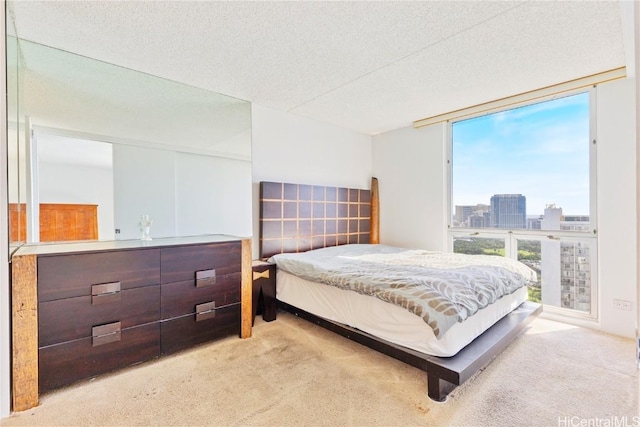 carpeted bedroom featuring a wall of windows and a textured ceiling