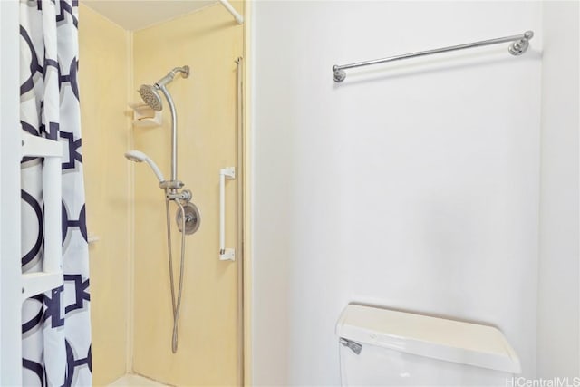 bathroom featuring toilet and curtained shower