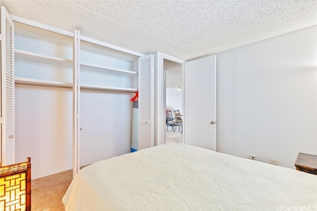 carpeted bedroom featuring a textured ceiling and two closets