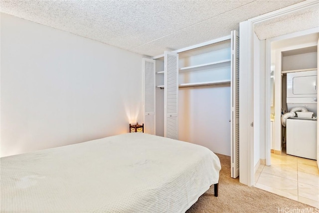 bedroom featuring stacked washer and dryer, a textured ceiling, and light carpet