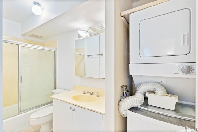 full bathroom with stacked washer / drying machine, vanity, toilet, and enclosed tub / shower combo