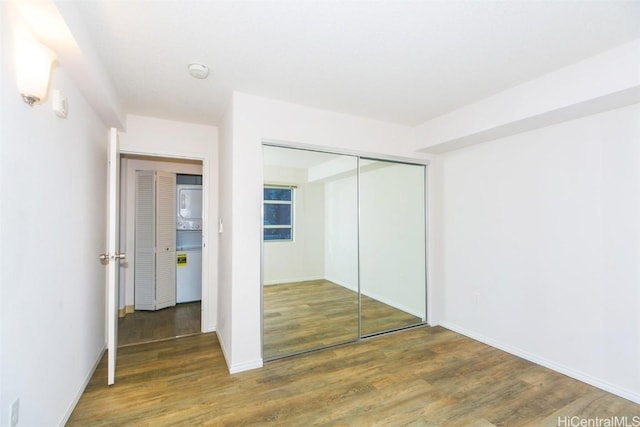 unfurnished bedroom with a closet and dark wood-type flooring