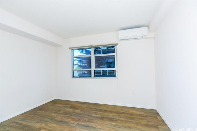 unfurnished room with a wall unit AC and dark hardwood / wood-style flooring