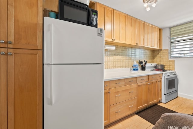 kitchen featuring backsplash, white appliances, and light hardwood / wood-style flooring