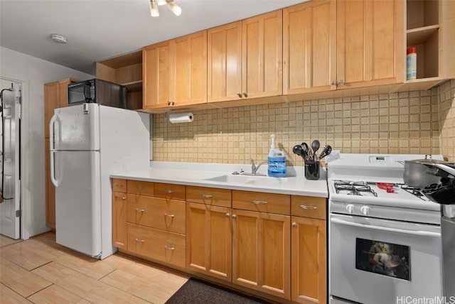 kitchen featuring white appliances, sink, light hardwood / wood-style floors, and backsplash