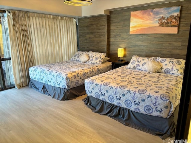 bedroom featuring hardwood / wood-style floors and wooden walls