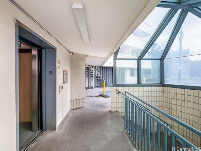 corridor featuring concrete floors and elevator