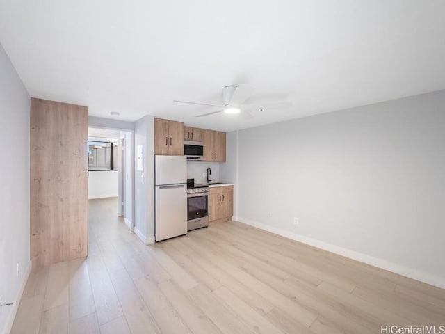 kitchen featuring ceiling fan, stainless steel appliances, and light hardwood / wood-style floors