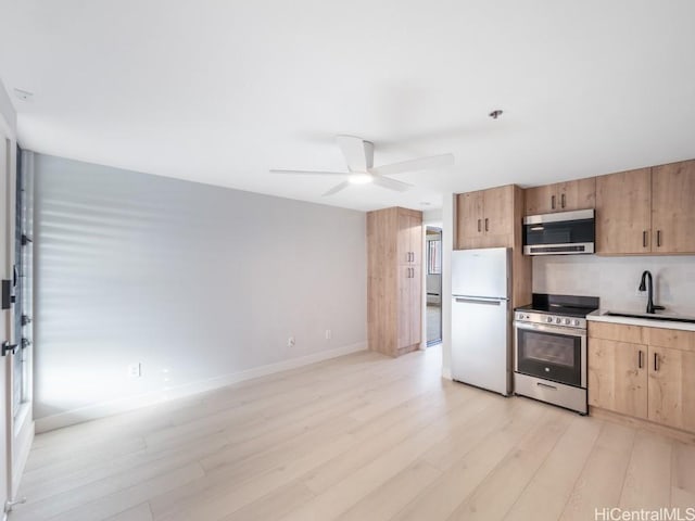 kitchen featuring ceiling fan, light wood-type flooring, sink, and appliances with stainless steel finishes