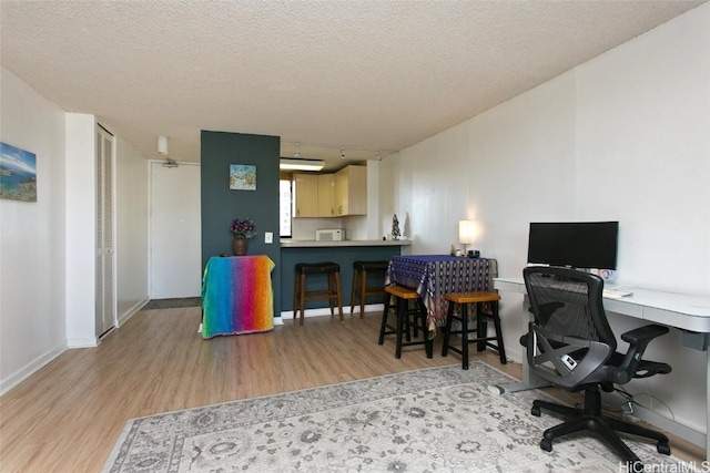 office space with light hardwood / wood-style flooring and a textured ceiling