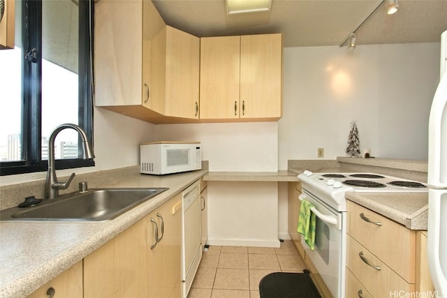 kitchen with light brown cabinets, white appliances, track lighting, sink, and light tile patterned floors