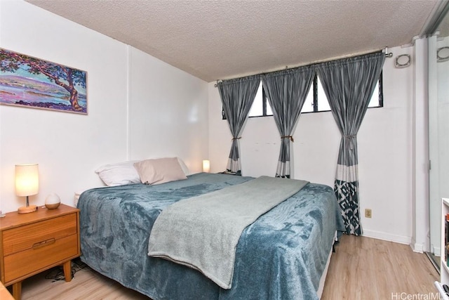 bedroom featuring light wood-type flooring and a textured ceiling