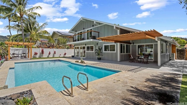 back of property featuring a patio area, a balcony, a pergola, and a fenced in pool