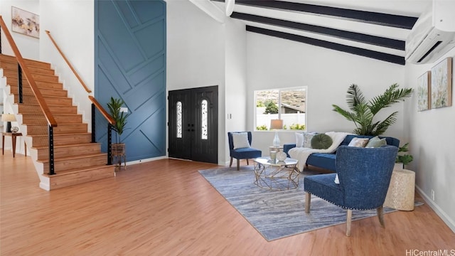 foyer featuring a wall mounted air conditioner, beam ceiling, hardwood / wood-style flooring, and high vaulted ceiling