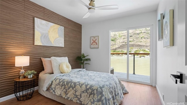 bedroom with hardwood / wood-style floors, access to outside, and ceiling fan