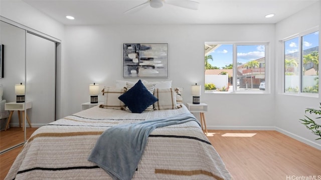 bedroom with ceiling fan, a closet, and wood-type flooring