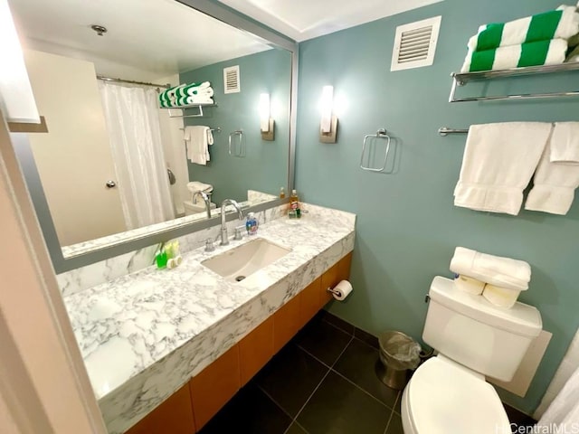 bathroom with toilet, tile patterned flooring, and sink