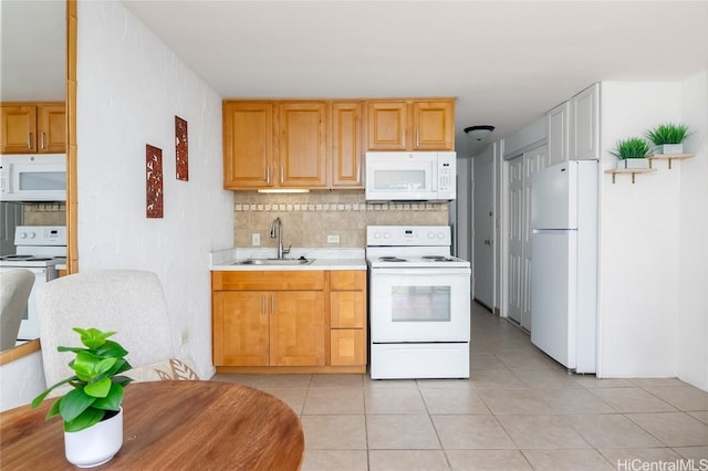 kitchen with tasteful backsplash, light countertops, light tile patterned flooring, a sink, and white appliances