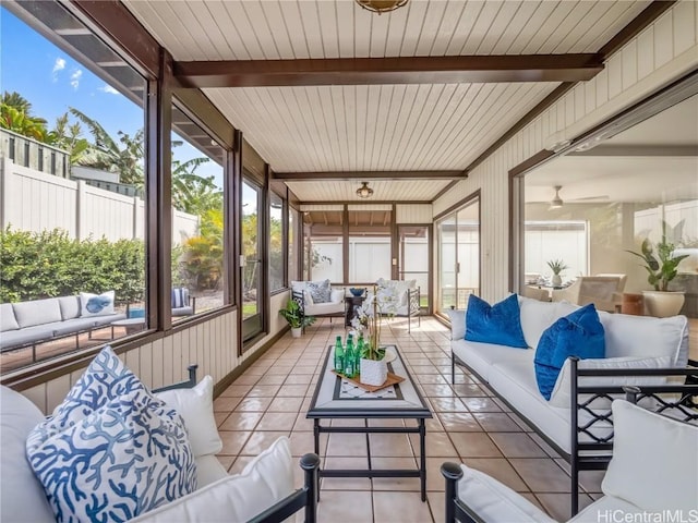 sunroom with beam ceiling and ceiling fan