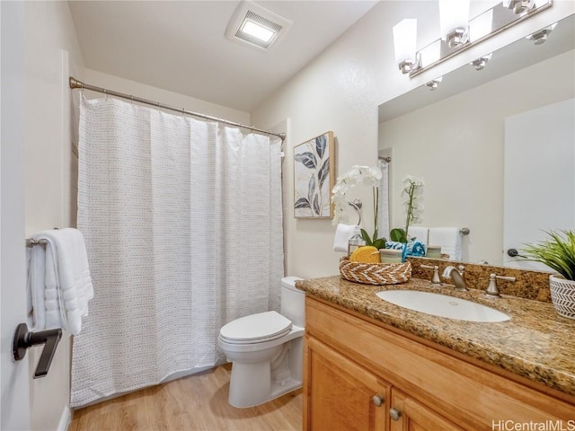 bathroom with toilet, vanity, and hardwood / wood-style flooring