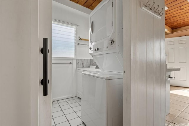 clothes washing area featuring wooden ceiling, stacked washer and dryer, and light tile patterned flooring