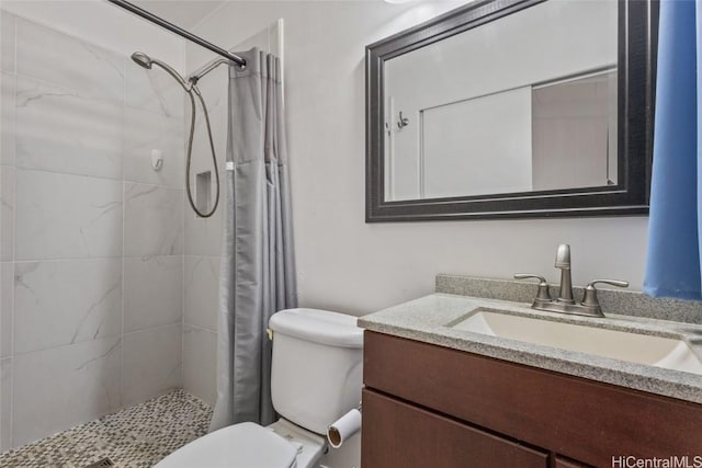 bathroom featuring curtained shower, toilet, and vanity