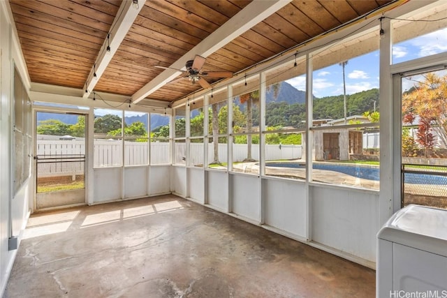 unfurnished sunroom with a mountain view, ceiling fan, and washer / dryer