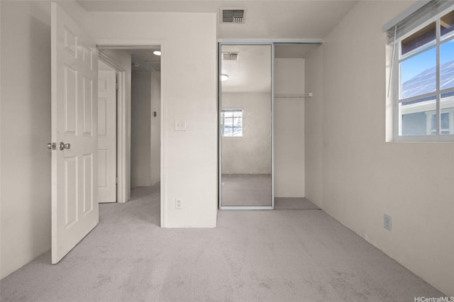 unfurnished bedroom featuring carpet, visible vents, and a closet