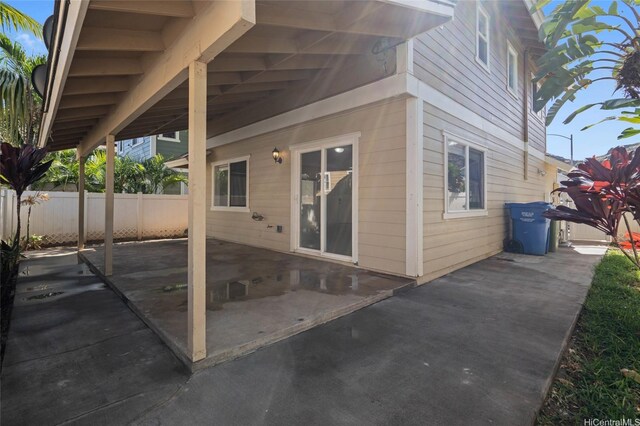 rear view of property featuring a patio and fence