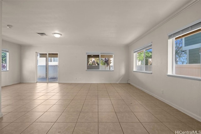 unfurnished room featuring crown molding, plenty of natural light, and light tile patterned floors