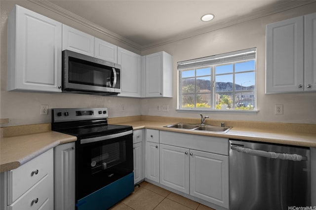 kitchen with ornamental molding, white cabinetry, light tile patterned flooring, appliances with stainless steel finishes, and a sink