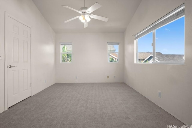 carpeted empty room with a healthy amount of sunlight and ceiling fan