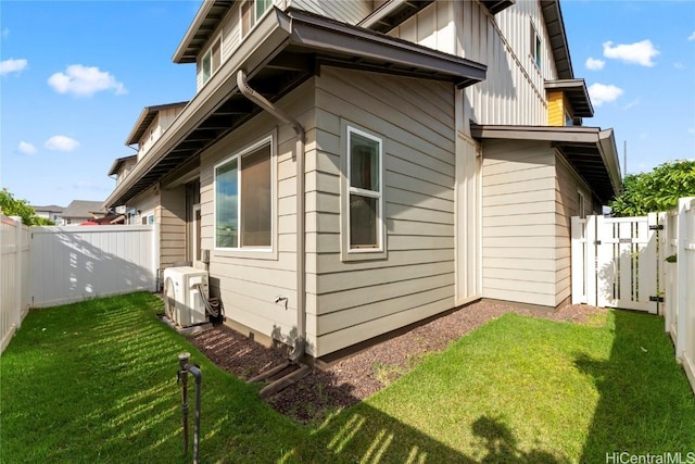 view of side of home with ac unit and a lawn