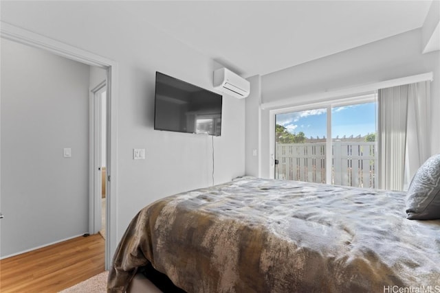 bedroom featuring access to exterior and a wall mounted AC