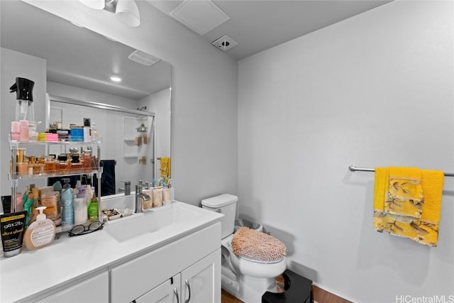 bathroom featuring walk in shower, vanity, and toilet