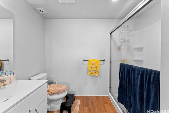 bathroom with vanity, hardwood / wood-style flooring, toilet, and a shower with door