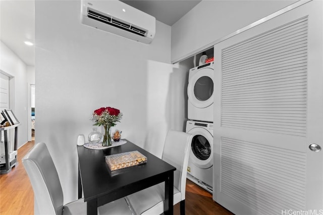 laundry room featuring a wall mounted air conditioner, wood-type flooring, and stacked washer and dryer