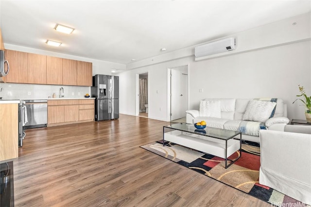 living room with hardwood / wood-style flooring, sink, and a wall unit AC