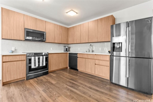 kitchen with dark wood-type flooring, light brown cabinetry, sink, appliances with stainless steel finishes, and decorative backsplash