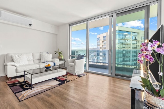 living room with expansive windows, a wall unit AC, and light hardwood / wood-style floors